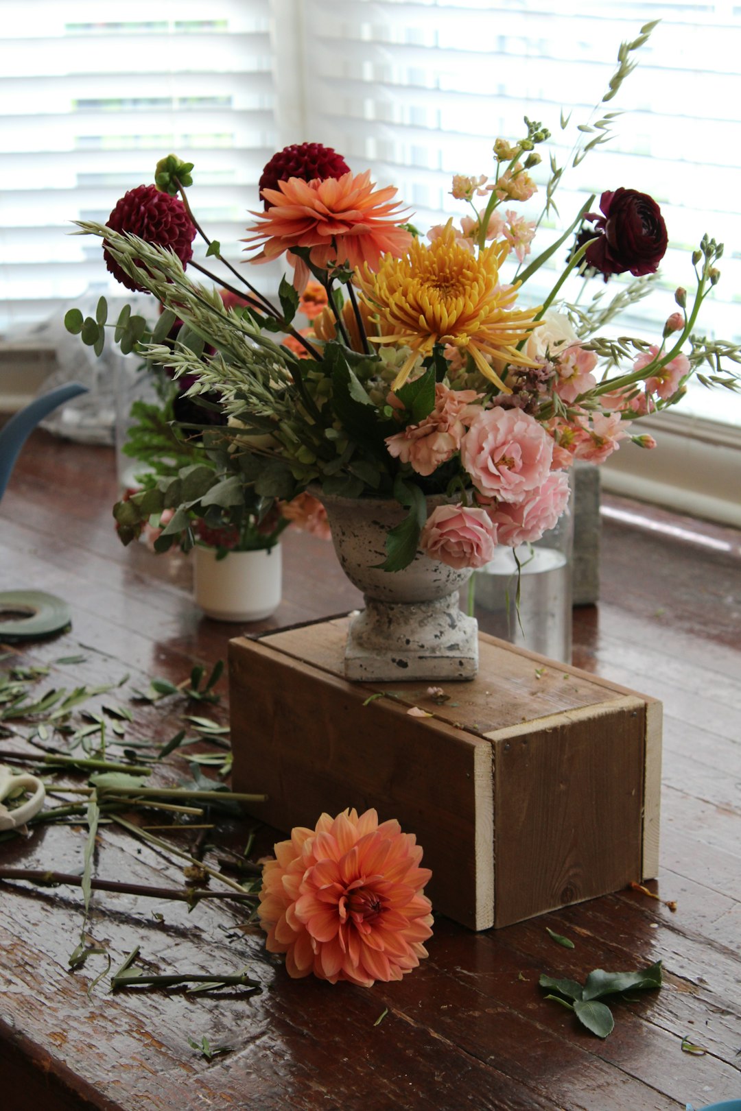 a-wooden-table-topped-with-a-vase-filled-with-flowers-kvswrsrma9s
